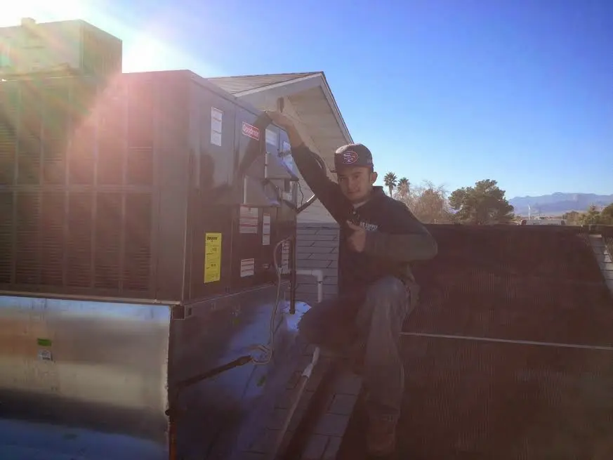 HVAC technician performing Air Duct Cleaning on a rooftop unit in Mukwonago
